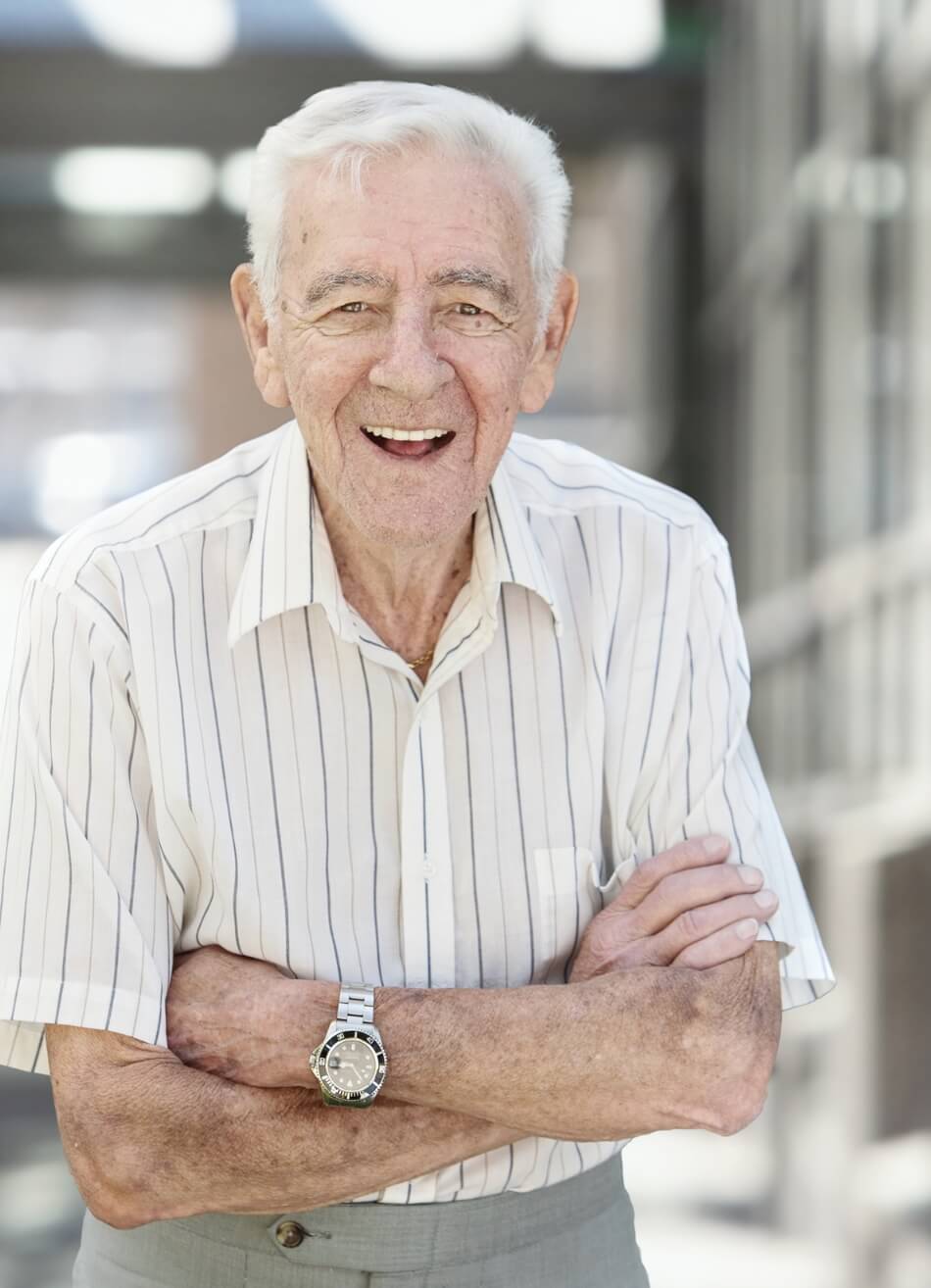 Smiling senior man standing outdoors at Amazing Grace Senior Living community