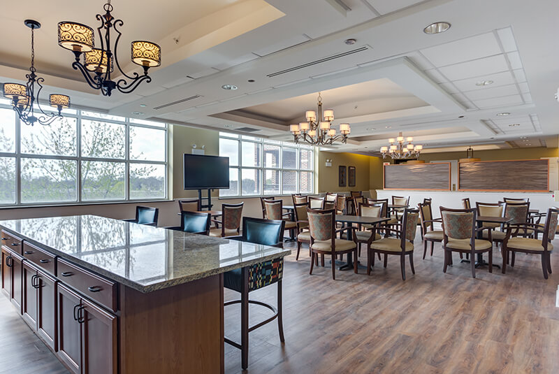 Memory care dining room with elegant chandeliers and comfortable seating at Amazing Grace Senior Living