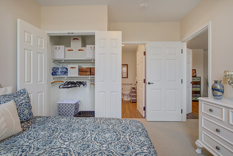 Spacious closet in one-bedroom apartment with organized shelving and storage bins at Amazing Grace Senior Living